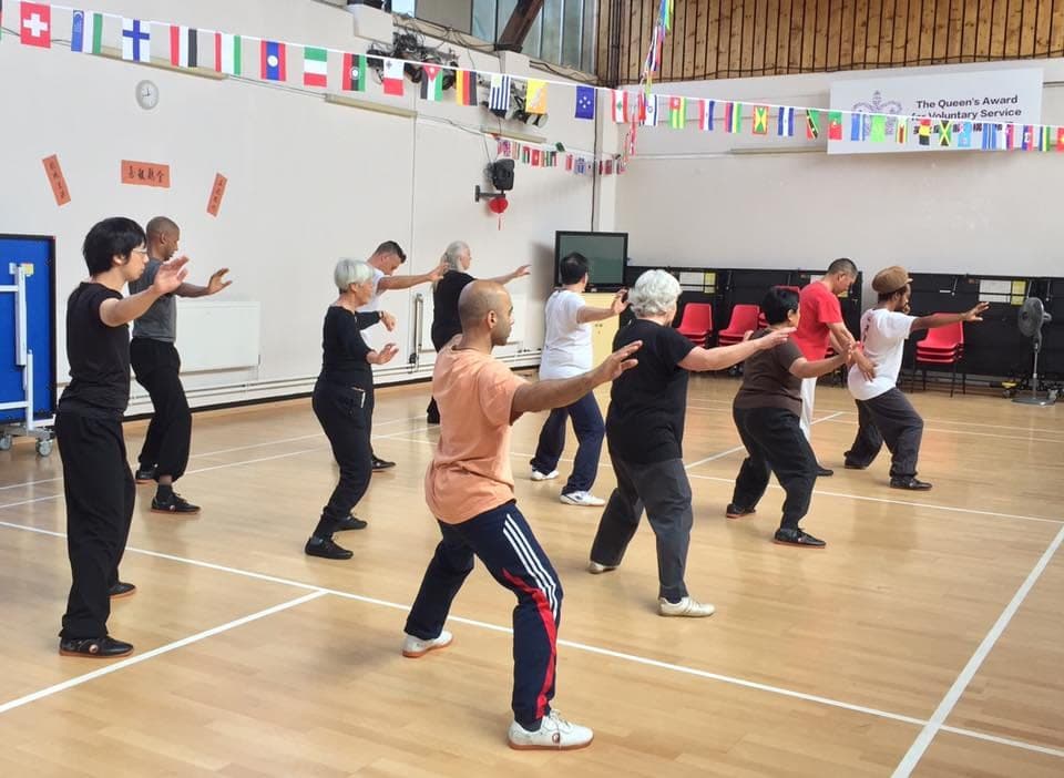 Students practise a form in a sports hall decorated with bunting of national flags