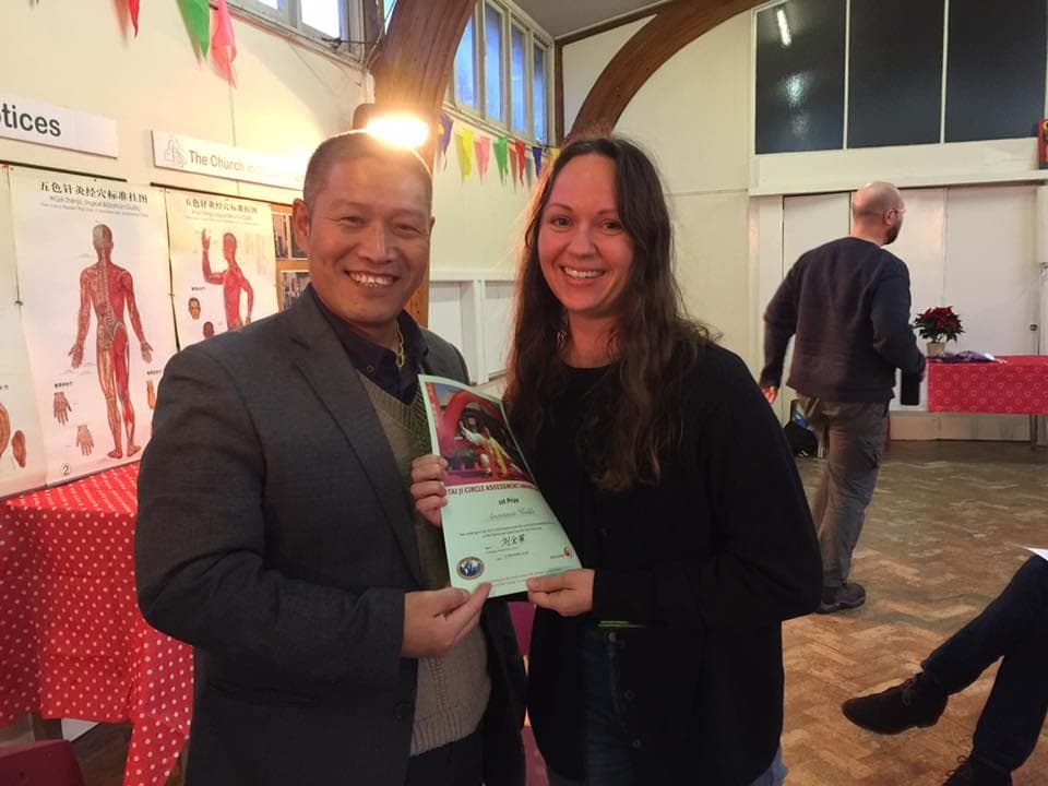 Shifu Liu and a prize winner hold up her Tai Ji Circle assessment award certificate