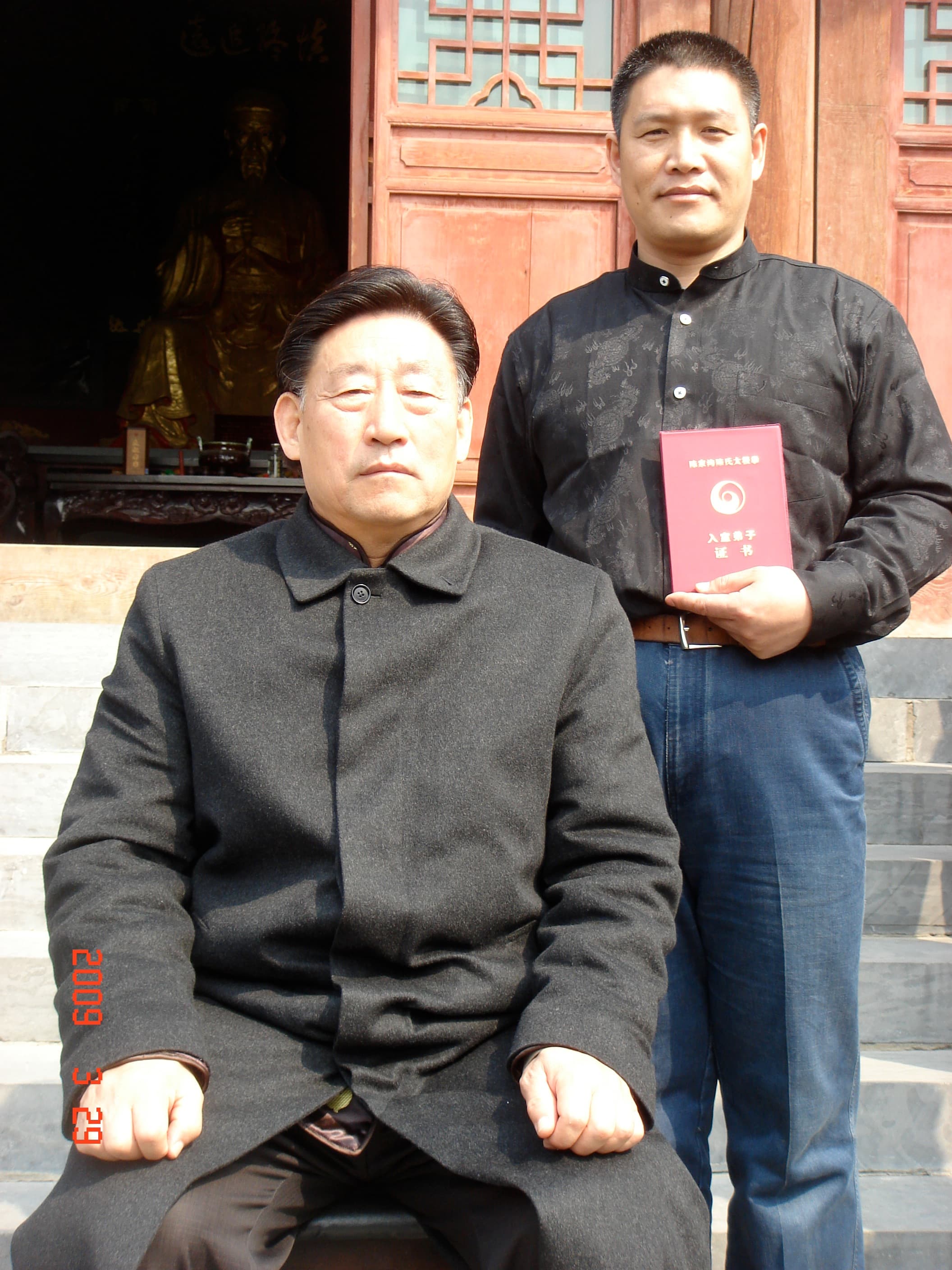 Shifu Liu holding his indoor-disciple certificate behind Grandmaster Chen Xiaowang, 2009
