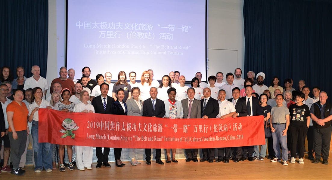 Councillor Sabrina Francis, Mr Gong Songqi and the Chinese delegation with Tai Ji Circle students and friends behind a red Belt and Road banner in London, 24 August 2019
