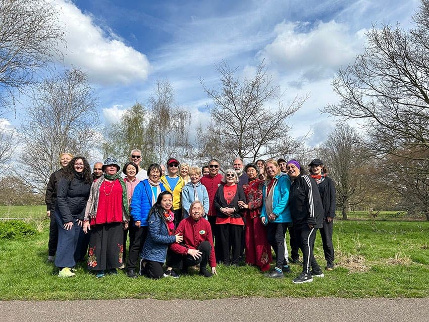 A group photo of students on the grass under a spring sky after a free class in the park