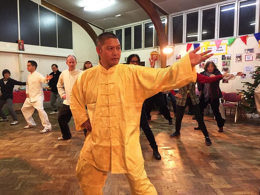 Shifu Liu in yellow silk leads Silk Reeling at the 2018 party, with students following behind him