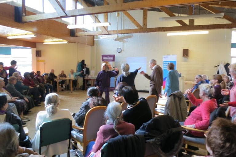 Chris Jones in purple demonstrates Taiji to a crowded hall of older people at an Age UK Barnet falls awareness day, March 2018